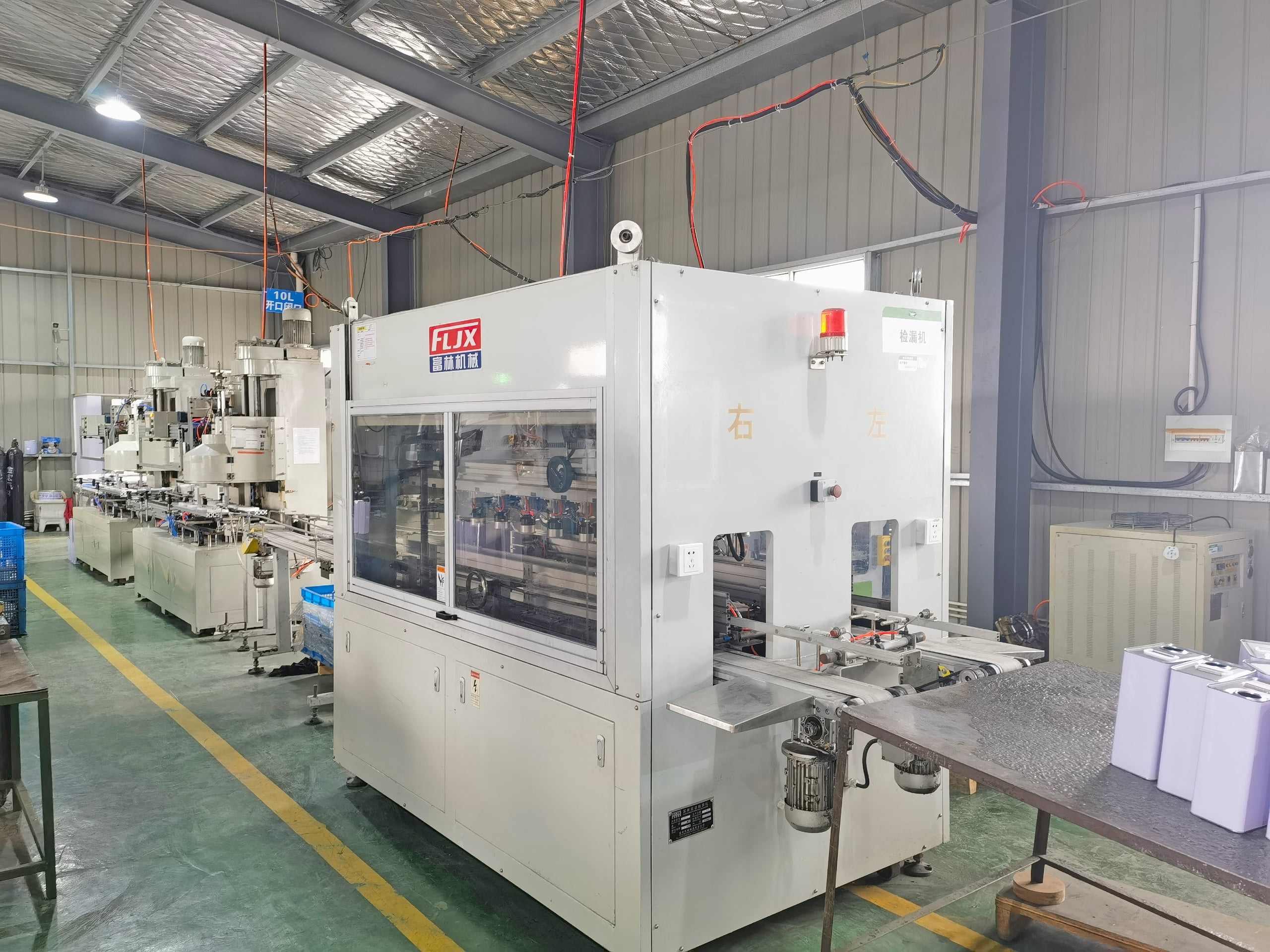 An automated leak testing machine on a production line for metal cans