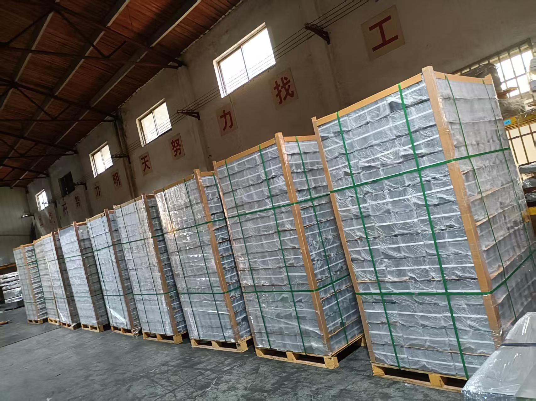 Multiple pallets of F-Style oblong tinplate cans wrapped in clear stretch film with green PET strapping bands on wooden pallets in Suzhou Jinqiao factory warehouse