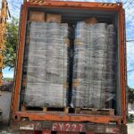 20L round steel pails loaded into a 40-foot HQ shipping container, wrapped in clear stretch film with green PET strapping, license plate 沪FY2227挂 (Shanghai registration)